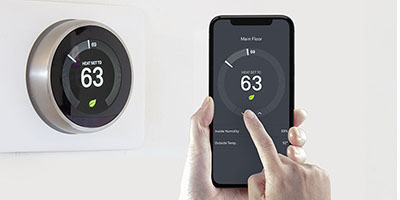 A person using a smart phone application saving energy with a wireless smart thermostat on a white background.