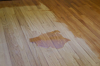 Polyurethane is spread on a hardwood floor.