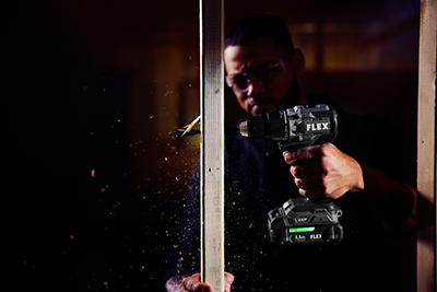 A worker drills a hole in a stud with the FLEX 1/2-inch 2-Speed Drill Driver with Turbo Mode.