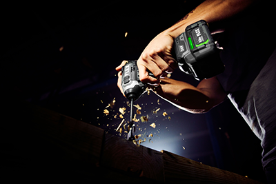 The FLEX 1/4-inch Quick Eject Impact Driver is used to bore a hole in a piece of lumber.