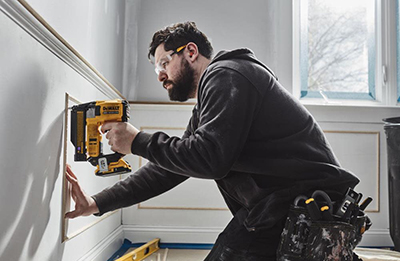 A DEWALT 23-guage pin nailer is used to attach crown moulding.
