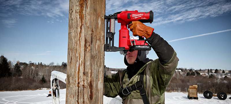 Person using M18 FUEL Utility Fencing Stapler on pol