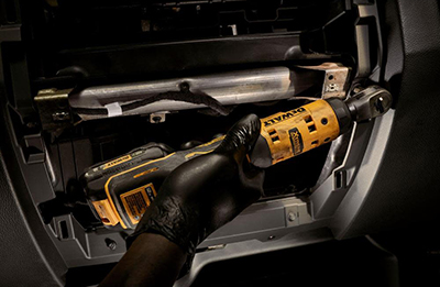 A mechanic used a DEWALT 12V MAX Xtreme 1/4-Inch Ratchet to remove a bolt under a motor.