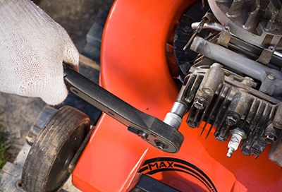 A spark plug is removed from a lawn mower.