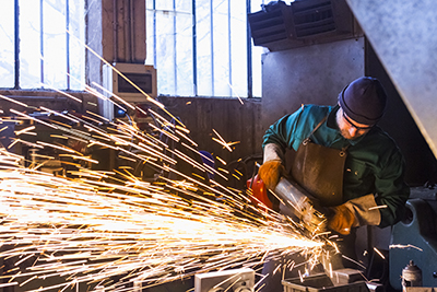 Sparks fly as a man uses an angle grinder safely