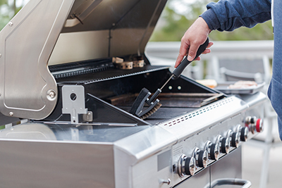 A grill brush is used to clean a gas grill.