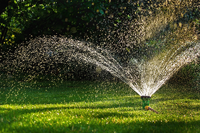 A large sprinkle is used to water a lawn.