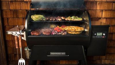 Several types of food cooking on a Traeger IRONWOOD 885 wood pellet grill.
