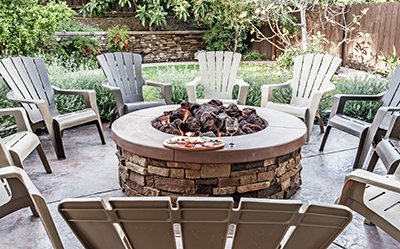 Several chairs sit around a stone fire pit.