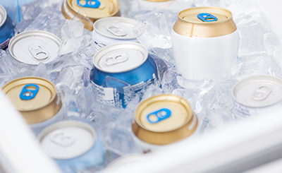 Drinks sitting in a cooler full of ice.