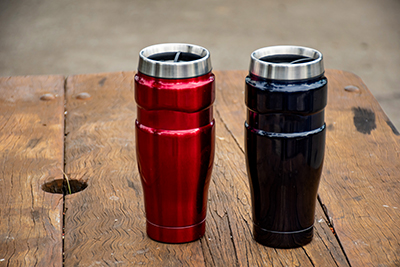 Insulated tumblers sitting on a wood workbench.