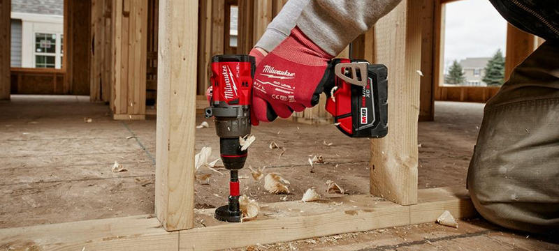 A Milwaukee M18 FUEL G4 Drill Driver is use to bore a hole in a wall frame.
