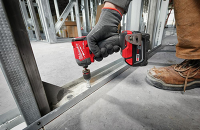 A Milwaukee M18 FUEL G4 Impact Driver is used to secure a piece of metal framing.