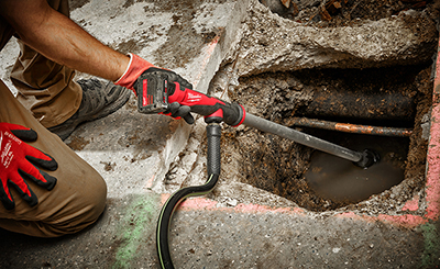 A Milwaukee M12 Stick Transfer Pump is used to clean under a leaking pipe.