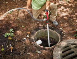 A Milwaukee M12 Stick Transfer Pump is used to pump water out of a sewage drain.