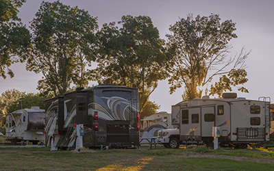 Several RVs sit parked on a campground.