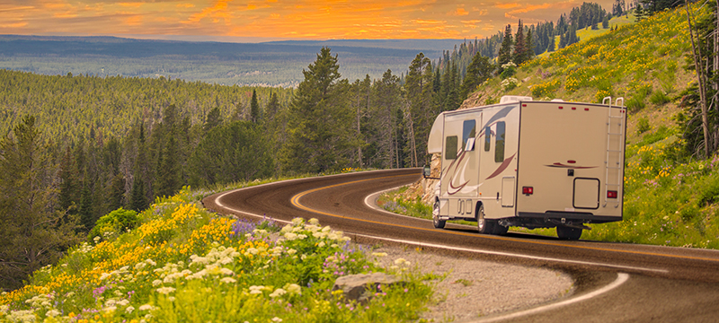 An RV ventures down a winding highway.