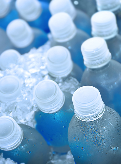 Several water bottles sit in ice in a cooler.