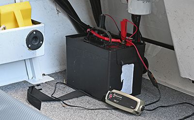 A battery on a boat being charge by a battery charger.