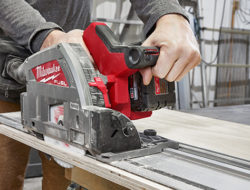 A Milwaukee M18 FUEL Plunge Track Saw makes a straight line cut in a piece of plywood.
