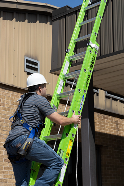 An electrician climbs a Werner AERO 20-Foot Extension Ladder.