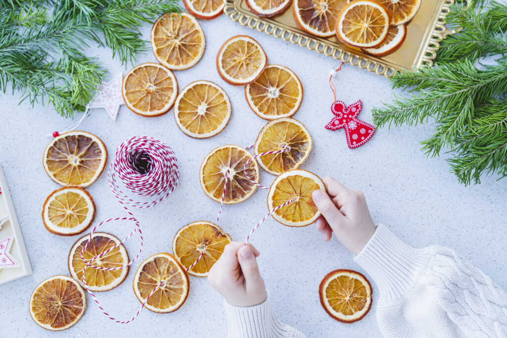 A child makes a garland of dried oranges for a holiday