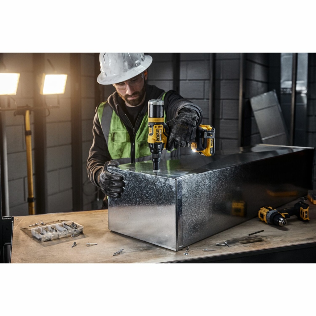 Sheet metal worker using the DEWALT DCF403D1 rivet tool on a section of duct work