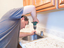 Man drilling hole in sink